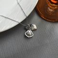 French shell pendant necklace in silver with pearl detail on a white ceramic plate - Shell Pearl Necklace 0369Y