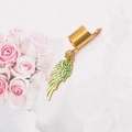 Detail view of golden spring dreadlock ring with green enamel wing charm and metal texture - Feather/Wing Style