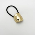 Detailed view of irregular golden alloy charm on a high-elastic black ponytail holder - Geometric Round Knot / Gold