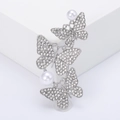 Détail d'une broche papillon argentée avec strass scintillants et perles élégantes - Argenté