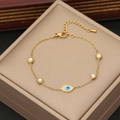 Elegant gold evil eye bracelet with blue charms and sparkling crystals on jewelry display - Blue Evil Eye
