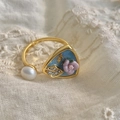Gros plan d'une bague baroque avec perle, fleur en émail bleu et détails de feuilles - Or 18K [Fleurs bleues + violettes]