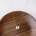 Collier chaîne dorée minimaliste avec un pendentif lettre M en nacre blanche élégante - Lettre M