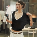 Detail of a black knit cover-up top featuring a deep V-neck and delicate textured finish - Black