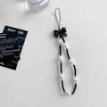 Detail of beaded phone strap with black bow, white faux pearls and silver spacers - White Pearl Bow