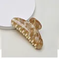 Macro detail of amber marble pattern hair claw clip with glossy finish on grey background - 10.7cm Semicircle / Amber Tortoiseshell
