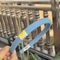 Minimalist light blue fabric headband featuring a woven texture and white Alline brand label - Haze Blue Narrow Headband with Yellow Letter Label