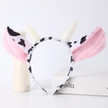 Detail shot of a plush cow headband with cute spotted ears and 3D horns for cosplay - Cow With Horns