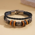 Detalle de una pulsera multicapa de cuero con relieve de girasol de metal y cuentas de madera - Estilo Flor de Sol (HB4550-1)