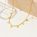 Elegante collana dorata con ciondoli a farfalla presentata su un piedistallo di pietra - Stile Farfalle Multiple (B303)
