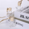Macro detail of star-shaped glass perfume bottles with wooden caps on white books - Star Shape Gold Wire Rope