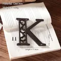 Industrial black cast iron letter K wall decor with vintage cutout flower pattern - Letter K