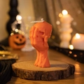 Orange skull hand scented candle on a rustic wood base for Halloween decoration - Hand-holding Skull / Orange