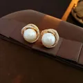 Elegante parelknopoorbel met goudkleurige zirkonia-omranding op bruin fluweel - Wit (Zilveren oorbelpost)
