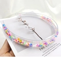 Macro detail of clear PVC headband filled with colorful heart and star shaped sequins - Soft Clay Cartoon Style