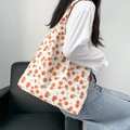 Detailed shot of canvas tote bag with orange fruit pattern carried by a model on shoulder - Orange Pattern