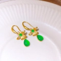 Vue détaillée des boucles d'oreilles fleur or vintage avec pierres précieuses vertes - Style Fleur Dorée et Pierre Verte en Forme de Goutte