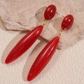 Dettaglio di orecchini vintage a goccia in resina rossa con maglia dorata su pietra - Rosso