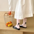 Detail of pink calf-high socks with black bows paired with black flat dress shoes - Large Bow Style (d1015) / Pink
