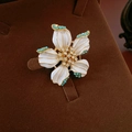 Détail d'une broche fleur vintage avec émail blanc, plaqué or et perles turquoise - Broche Fleur