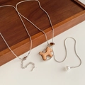 Detailopname van houten paard hanger met zilveren slangenketting en parel accent - Hobbelpaard Hanger / Zilver/Bruin