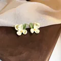 Elegant cream white flower stud earrings with yellow center and green leaf detail - Beige Flower Leaf