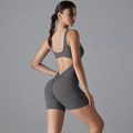 Detail of grey yoga bodysuit featuring a ruched scrunch butt design and open back detail - Dark Gray