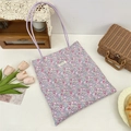 Détails du motif floral et de l'étiquette sur un sac cabas en toile avec anses mauves - Motif Floral Complet