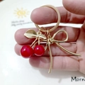 Golden keychain with red cherry pendants and a metal bow ornament on a white plate - Red Cherry Gold Bow Buckle (Cherry Y)