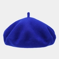 Close-up of thick wool felt texture and decorative top tail on a royal blue beret hat - One Size / Sapphire Blue