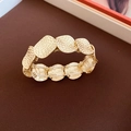 Vista dettagliata del bracciale elastico con maglie ovali dorate e texture martellata - Stile a Piastra Rotonda Martellata Oro