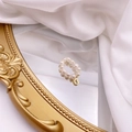Detail of woven double-row freshwater pearl ring with a gold G-letter charm on a mirror - Letter G