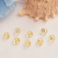 Fermoirs d'oreilles en silicone plaqué or 18K sur tissu blanc avec accents floraux - Or 18K