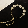 Vintage gold starburst bracelet with adjustable drawstring closure and white shell inlay - Round Shell