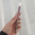 Purple and gold eyeshadow blending brush with soft white bristles held in hand - Purple Grape - White Smudge Brush