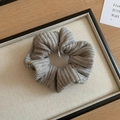 Detail of a grey hand-knitted scrunchie with soft woven texture in a black jewelry box - Knitted Scrunchie / Gray