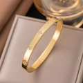 Gold titanium steel clover bracelet with diamonds shown on a luxury display box - Gold