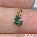 Macro shot of gold pendant with green zircon heart, size 6.2x10.6mm detail on fingertip - Green
