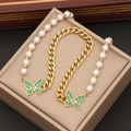 Collana di perle dorate con ciondolo a farfalla verde su un portagioie in beige - 1# Collana