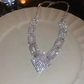 Detail van vierkante geometrische ketting met glinsterende strass op wit bord - Zilver
