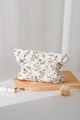 Dettaglio della borsa per cosmetici in cotone floreale su un vassoio di legno decorativo - Foglie Verdi Con Eleganti Fiori Rossi