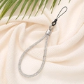 Detail of luxury sparkling rhinestone phone wrist strap on soft textured fabric background - White