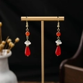 Detailed close-up of red teardrop earrings with white pearls and cloud charms - Red Orange White Dangle