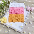 Detailed knit texture of three soft nylon baby headbands with large bows in a set - 3-Pack / White Pink Ginger Yellow