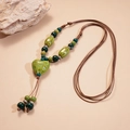 Détail du pendentif cœur en céramique verte avec perles sur un cordon brun fait main - Vert