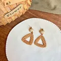 Dettaglio di orecchini boho in rafia intrecciata con perline di legno su un piatto di ceramica - Stile con Perle in Legno Intrecciate a Triangolo Cavo (4# Ago in Argento - Caffè - Triangolo)