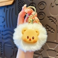 Cute white plush bear keychain with yellow accents and a golden metal ring held in hand - Beige