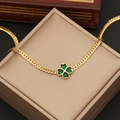 Collar de trébol dorado con gema verde sobre un joyero de color beige - 1# Collar