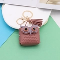 Detail of rose pink owl leather keychain featuring fringe tassel and gold hardware charms - Dusty Pink