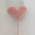 Pink handmade crochet heart flower with knitted texture on a slender green stem - Nude Pink